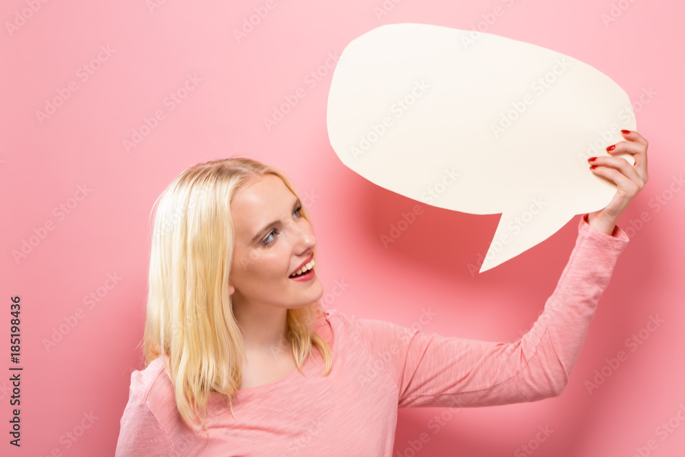 Young woman holding a speech bubble on a solid background Young woman holding a speech bubble on a solid background