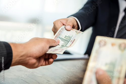 Photography Businessman giving  United Arab Emirates dirham money