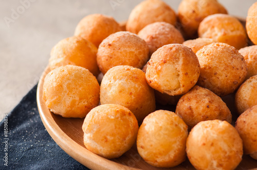 Small cottage cheese doughnuts (castgnole) served on a wooden plate. Festive dessert.