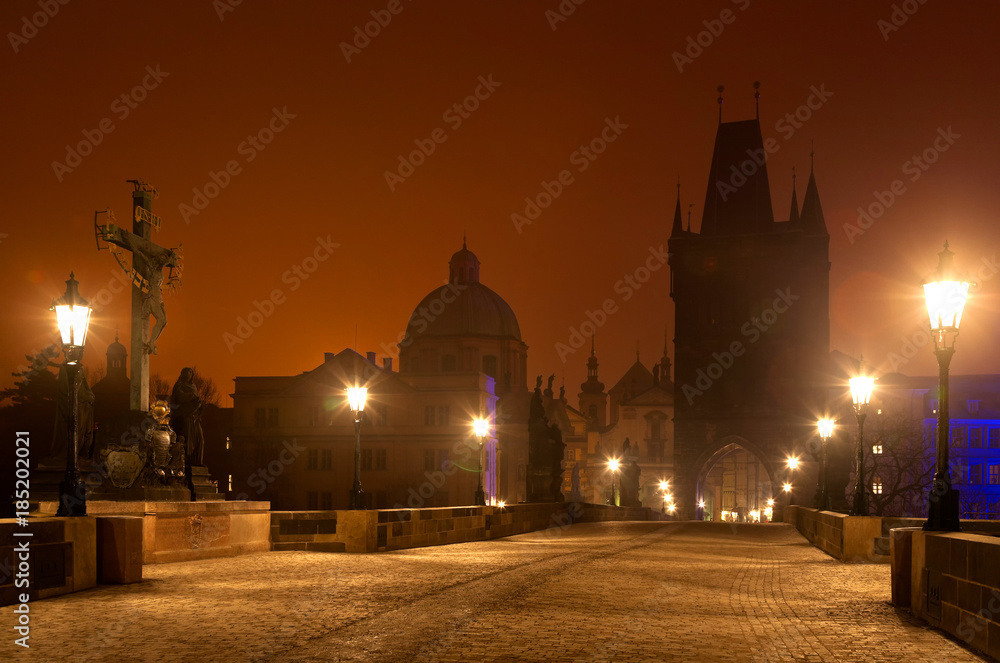 Night Prague. Beautiful cityscape with silhouettes of watchtowers on the Charles Bridge in the winter twilight