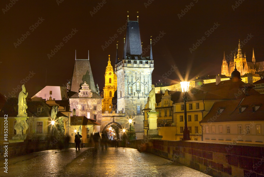Evening in Prague. Beautiful cityscape with the Bridge Towers of Charles Bridge and the spiers of St. Vitus Cathedral during the winter holidays