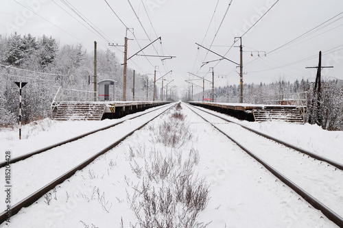 snow-covered train tracks and the platform in the suburbs