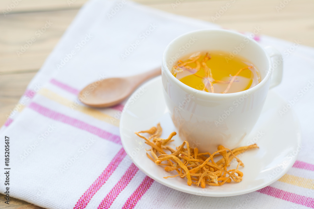 Dried Cordyceps Militaris Mushroom with Cup on white cotton fabric background Dried Cordyceps Militaris Mushroom with Cup on white cotton fabric background