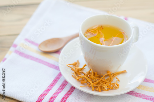 Dried Cordyceps Militaris Mushroom with Cup on white cotton fabric background