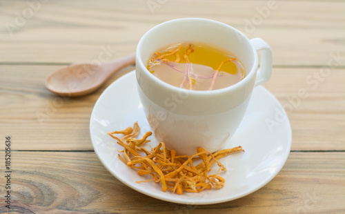 .Dried Cordyceps Militaris Mushroom with Cup on wooden table background