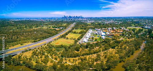 Aerial panorama of Eastern Freeway and Melbourne CBD skyscrapers on bright summer day