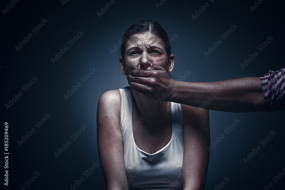 Man covering young woman's mouth Man covering young woman's mouth