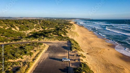 Australian Beach at Sunrise with a person in a car enjoying the view. The long beach is located in Saint Andrews Australia. photo