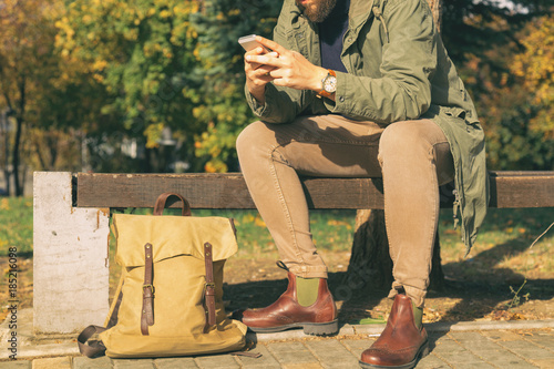 Modern guy using cellphone outdoots. photo