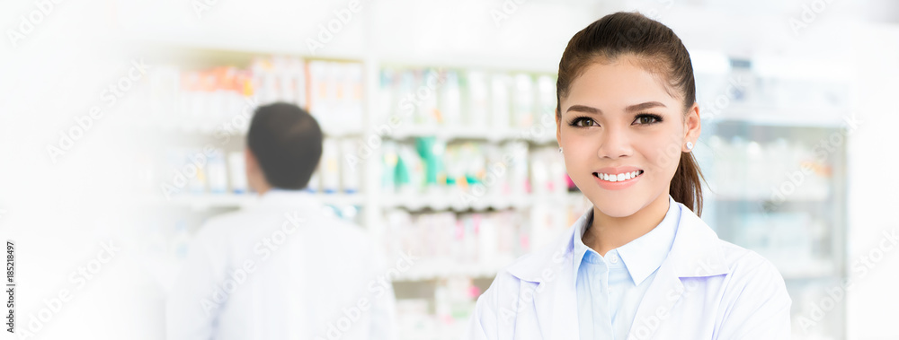 Smiling Asian female pharmacist in chemist shop or pharmacy