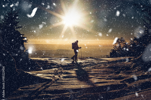 Fotografie backcountry skier reaching the summit at sunset
