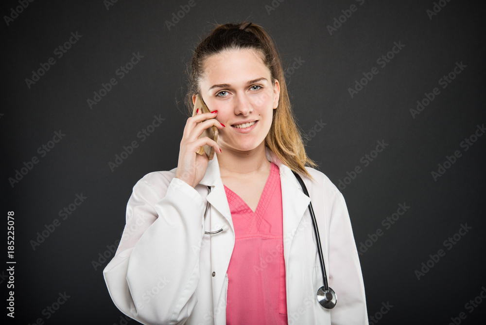 Young doctor portrait holding and talking at phone Young doctor portrait holding and talking at phone