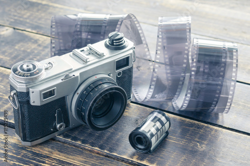 Photography Old film camera, black and white film and film roll on a wooden