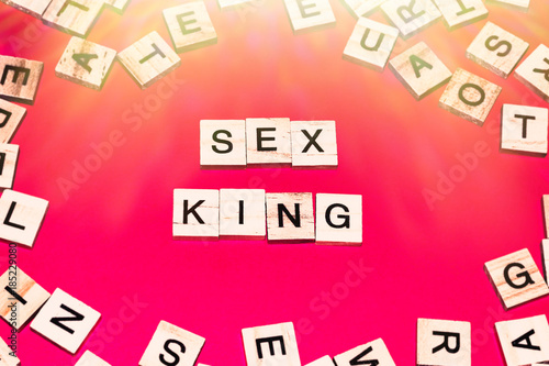 Wooden blocks on a red background spelling words Sex King