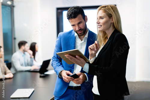 Attractive business couple using tablet in their company