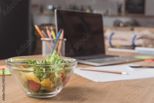 close-up shot of workplace with laptop and healthy salad