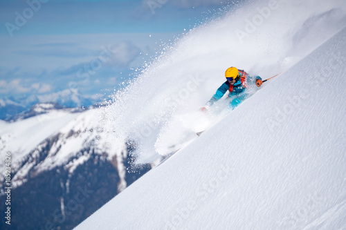 A male skier does off-piste skiing in fresh powder snow in the Sportgastein ski area in Austria.