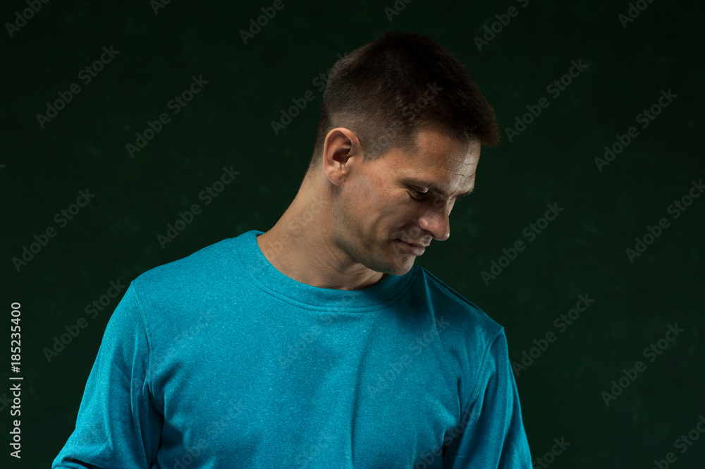 Portrait of young handsome man looking downwards on green vintage background