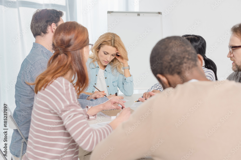 Fototapeta premium multiethnic people gathered together and taking notes during group therapy