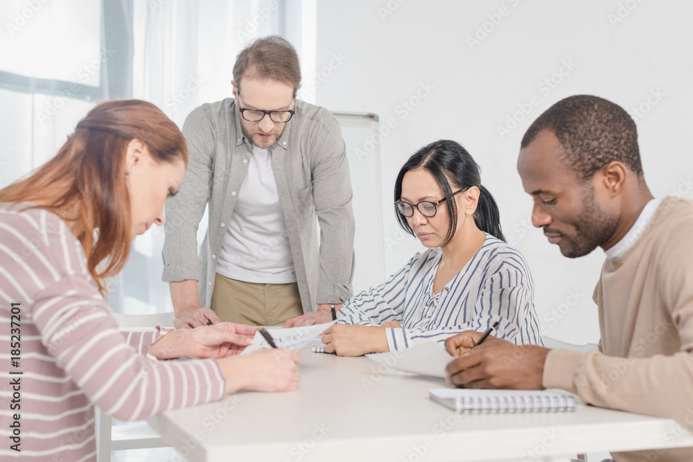 multiethnic middle aged business people working with papers together multiethnic middle aged business people working with papers together