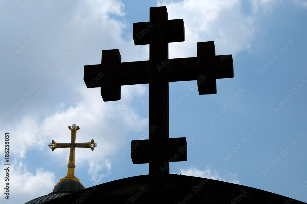 Outline of Coptic and Greek Orthodox crosses on sky background in Jerusalem.
