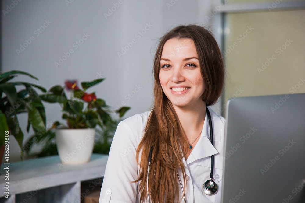 Portrait of a Young professional female doctor smiling at clinic. Close-up of a medicine stuff at hospital with computer Portrait of a Young professional female doctor smiling at clinic. Close-up of a medicine stuff at hospital with computer
