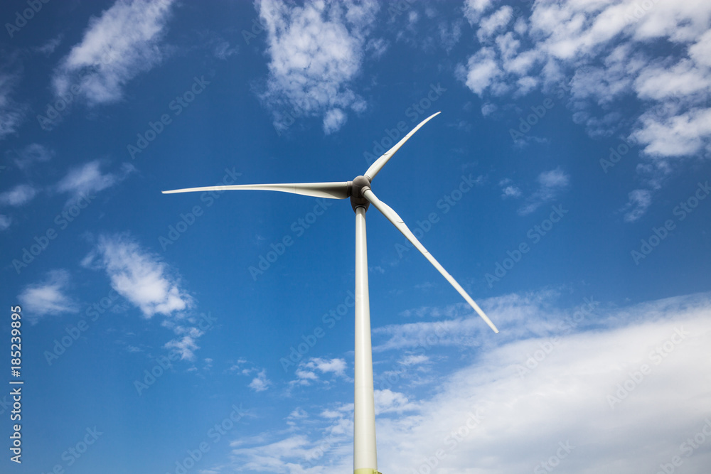 Wind power turbine close up view over blue sky Wind power turbine close up view over blue sky