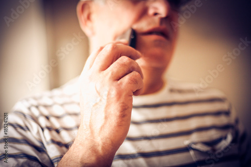 Senior man shaving. Focus on hand.