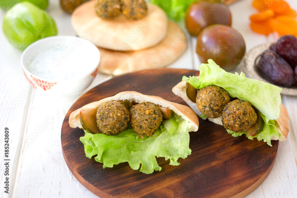 Nice vegetarian falafel in pita bread on wooden board. Nice vegetarian falafel in pita bread on wooden board.