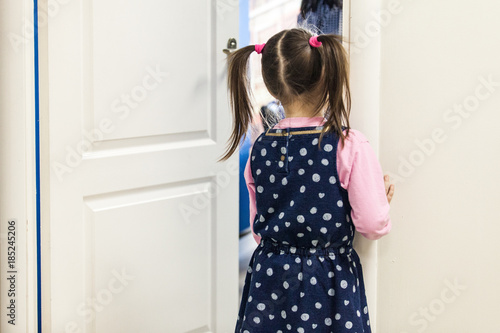 Girl  5-7  looking into classroom through the door