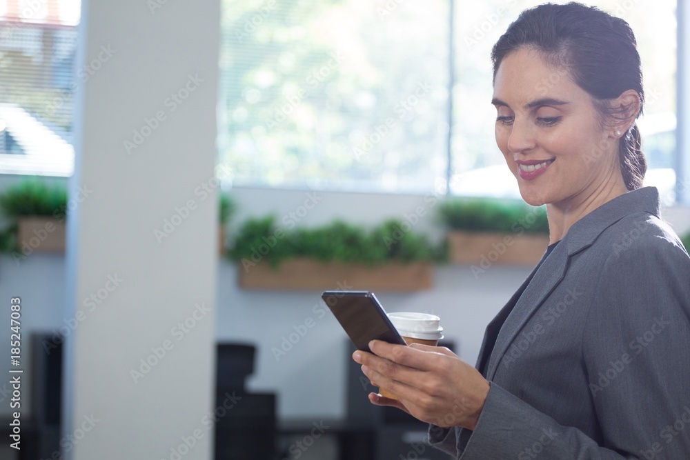 Female executive using mobile phone while having coffee Female executive using mobile phone while having coffee
