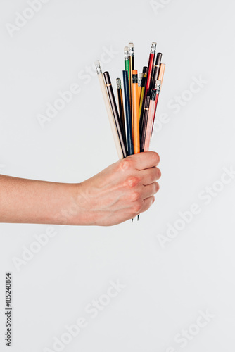Close-up view of female hand with colorful pencils isolated on white background