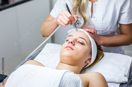 Cosmetologist is doing procedure for young girl. Procedure of Microdermabrasion. Model, close-up. Cosmetological clinic. Healthcare