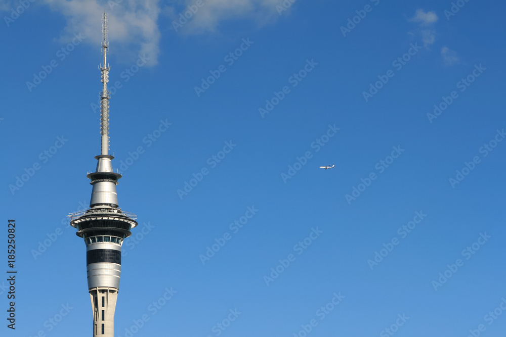 Auckland sky tower and flying airplane in air Auckland sky tower and flying airplane in air