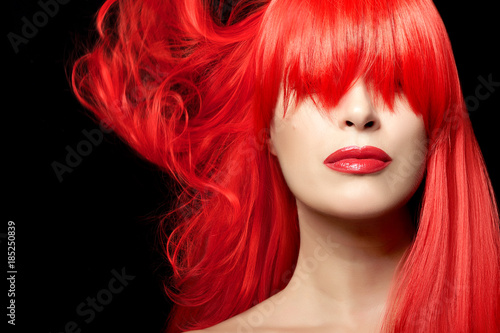 Young woman with red hair against black background