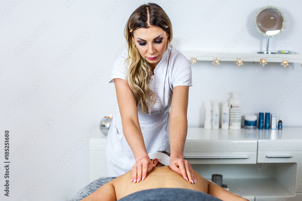 Cosmetologist/Therapist is doing body massage for young girl, woman. Model. Cosmetological clinic. Healthcare Cosmetologist/Therapist is doing body massage for young girl, woman. Model. Cosmetological clinic. Healthcare