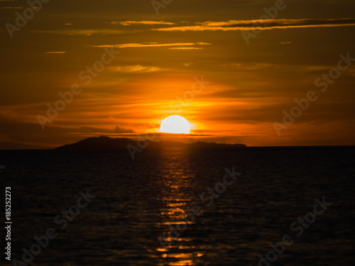 The sunset with island or mountain in the sea and colorful sky and clouds.
