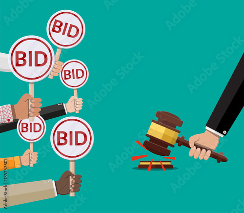 Hands holding auction paddle and hammer