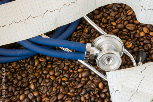 Coffee or caffeine and heart arrhythmias (irregular heartbeat). Stethoscope and ECG tape on background of coffee beans. Effect and risk of drinking coffee or caffeine on cardiac arrhythmia development photo