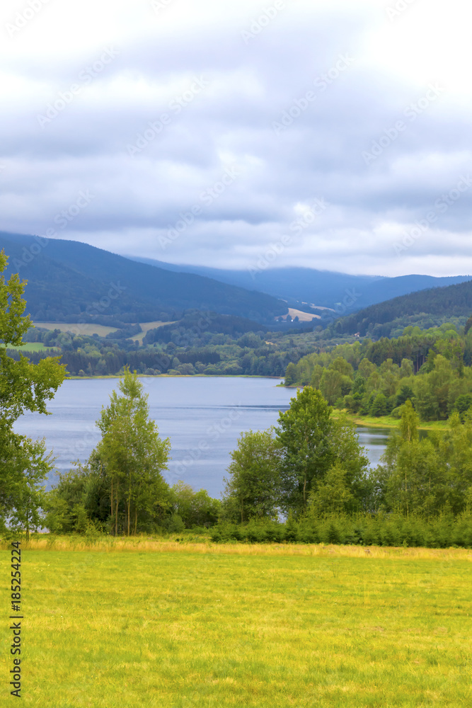 Obraz premium Summer landscape glassy surface of a calm river and trees 