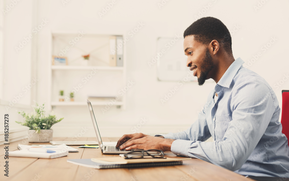 Young black businessman working with laptop