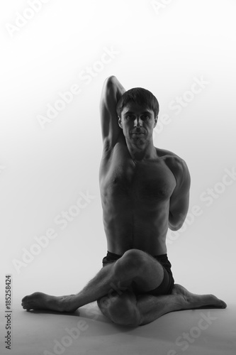 Young attractive man shows poses in yoga