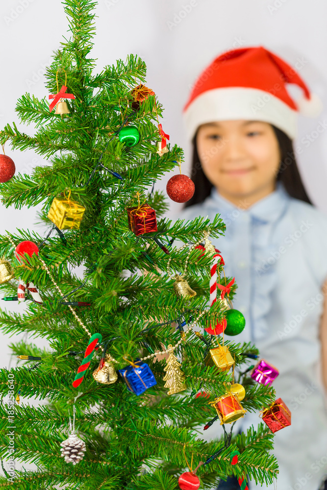 Girl is being decorate her Christmas tree with many gifts and lights Girl is being decorate her Christmas tree with many gifts and lights