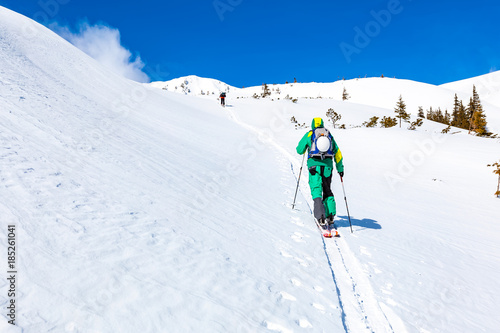 A skier is climbing the mountain ridge.