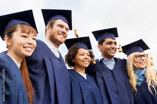 happy students or bachelors in mortar boards photo