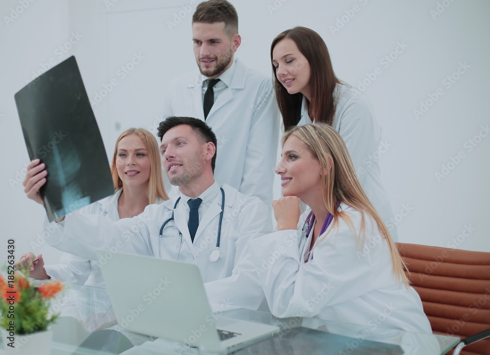 Smiling doctors are analyzind the x-ray. Medical office interior Smiling doctors are analyzind the x-ray. Medical office interior