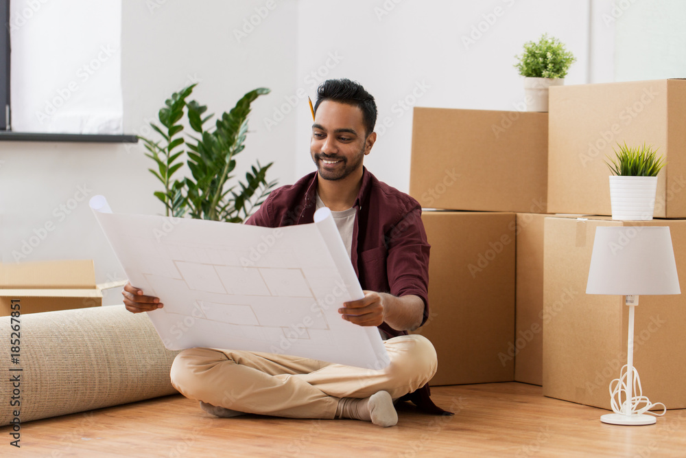 man with blueprint and boxes moving to new home man with blueprint and boxes moving to new home