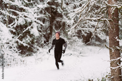 Young man running in the snow in Austria