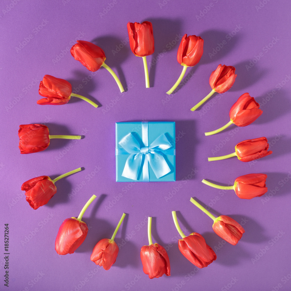 Set of red tulips with blue gift box purple background Set of red tulips with blue gift box purple background