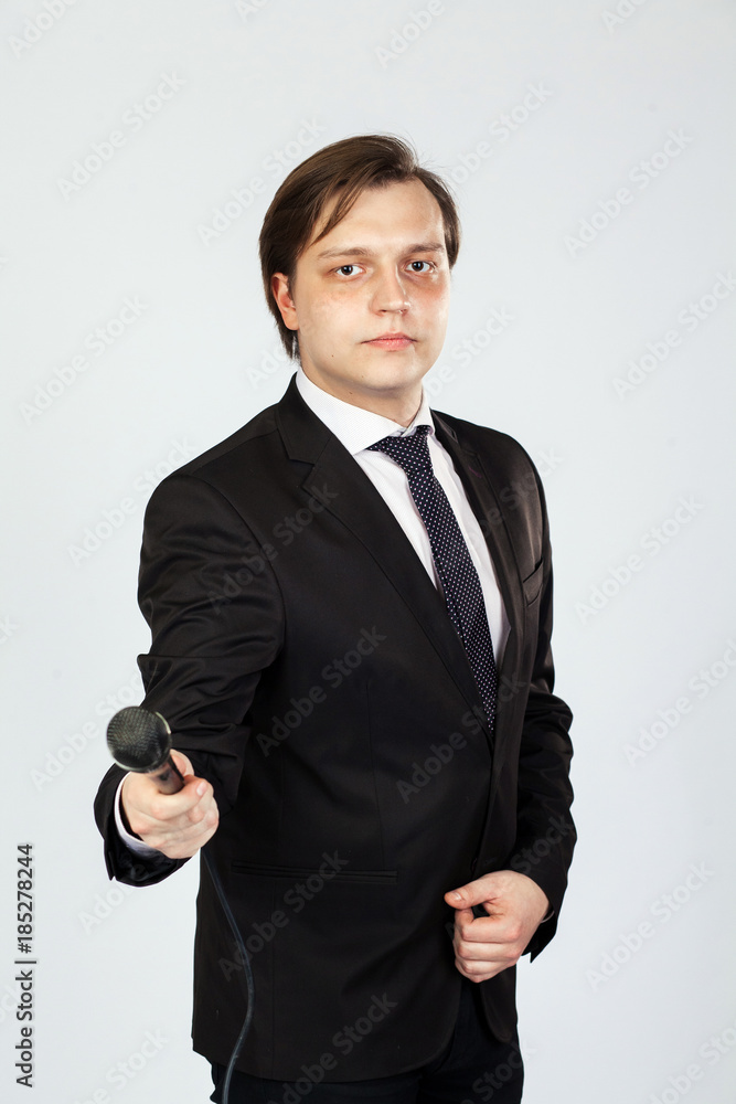 Fototapeta premium The interviewer. Young elegant man holding microphone